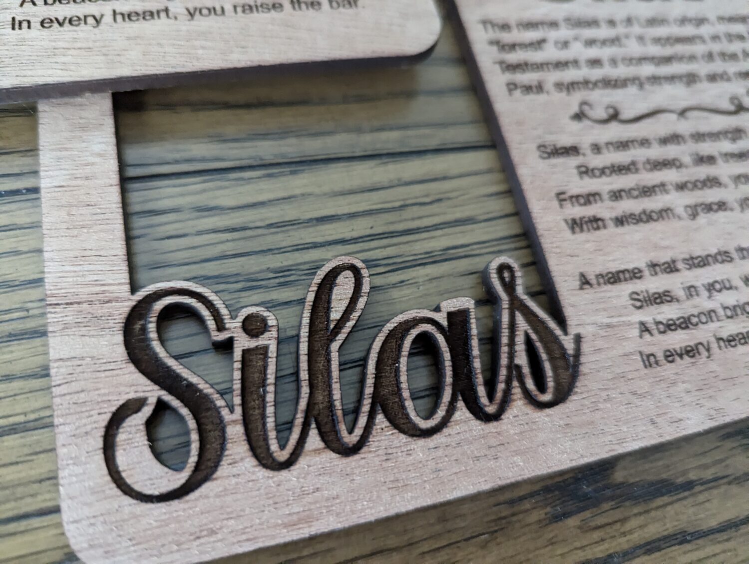 Macro photo of laser-engraved 'Silas' script on Cherry hardwood